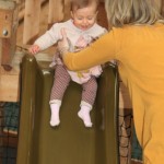 A little girl enjoying the slide in the under 5s area of the indoor treehouse