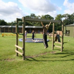 Children playing on the monkey bars and trampolines in the outdoor playarea